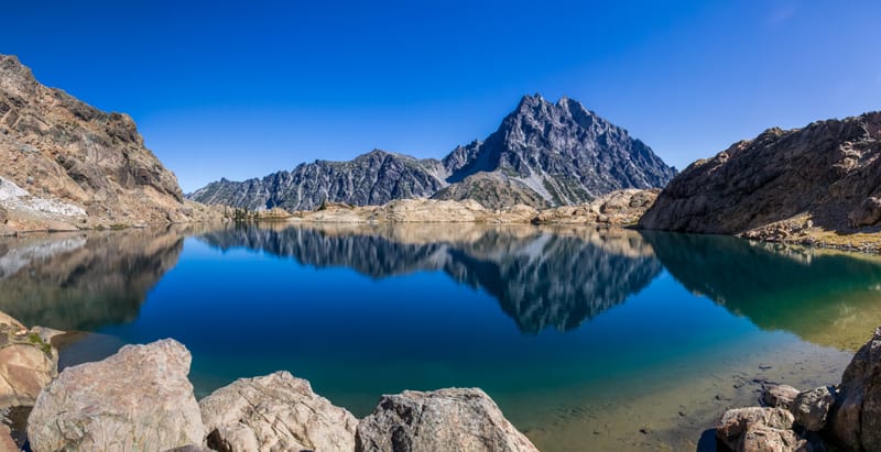 A sharp mountain peak reflected in a blue lake